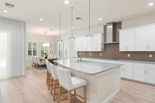 8017 Chilton Dr, Orlando, FL 32836 - kitchen featuring wall chimney exhaust hood, a sink, light wood-type flooring, backsplash, and recessed lighting