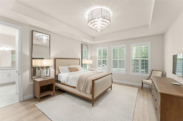 8017 Chilton Dr, Orlando, FL 32836 - bedroom featuring a raised ceiling, light wood-type flooring, baseboards, and a chandelier