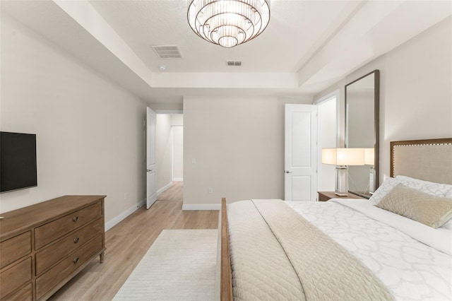 8017 Chilton Dr, Orlando, FL 32836 - bedroom featuring a raised ceiling, light wood-style flooring, a chandelier, and baseboards