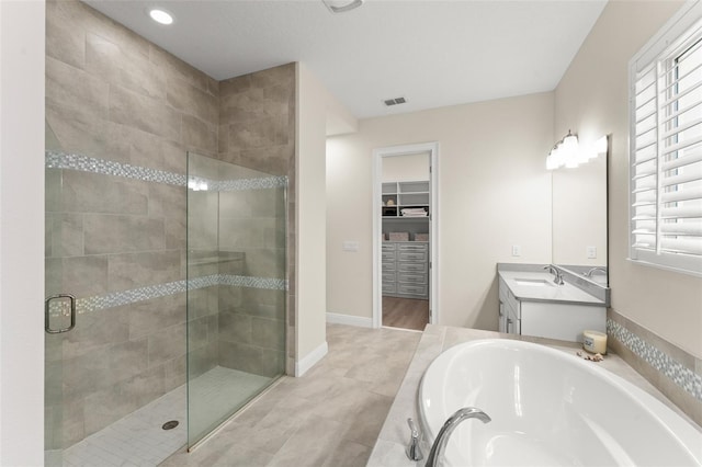 8017 Chilton Dr, Orlando, FL 32836 - full bathroom with a stall shower, a bath, vanity, a spacious closet, and baseboards