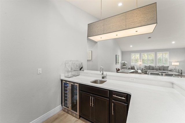 8017 Chilton Dr, Orlando, FL 32836 - kitchen with a sink, beverage cooler, open floor plan, light wood-style floors, and light countertops