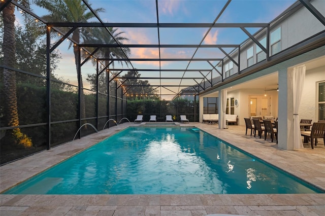 8017 Chilton Dr, Orlando, FL 32836 - pool at dusk featuring a patio, an outdoor pool, glass enclosure, and a ceiling fan