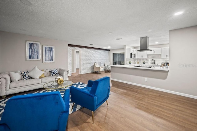 living room with baseboards, recessed lighting, wood finished floors, and a textured ceiling