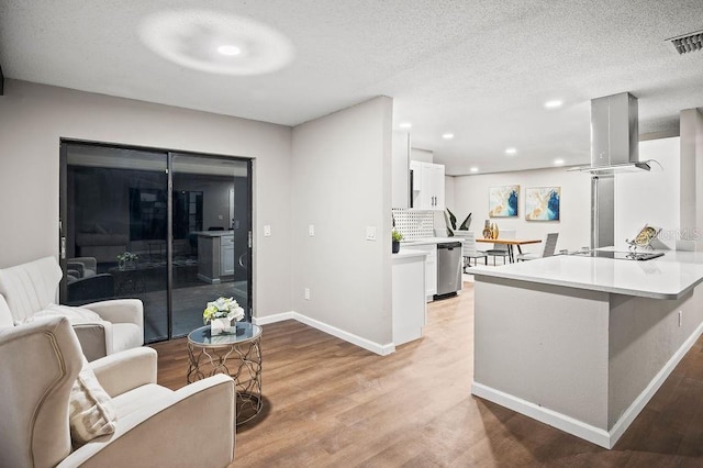 kitchen featuring baseboards, dishwasher, white cabinetry, and island exhaust hood
