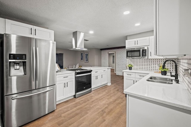 kitchen featuring a textured ceiling, white cabinetry, a sink, island range hood, and stainless steel appliances