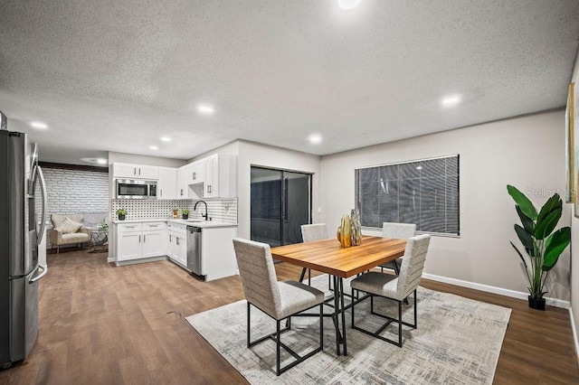 dining area featuring recessed lighting, a textured ceiling, wood finished floors, and baseboards