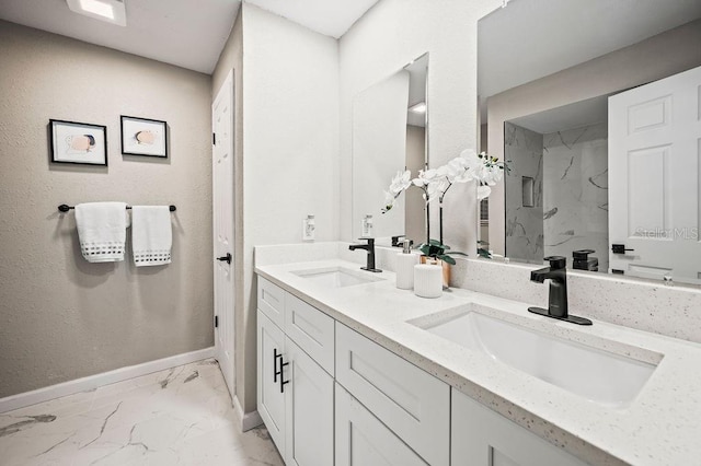 bathroom with baseboards, marble finish floor, a marble finish shower, and a sink