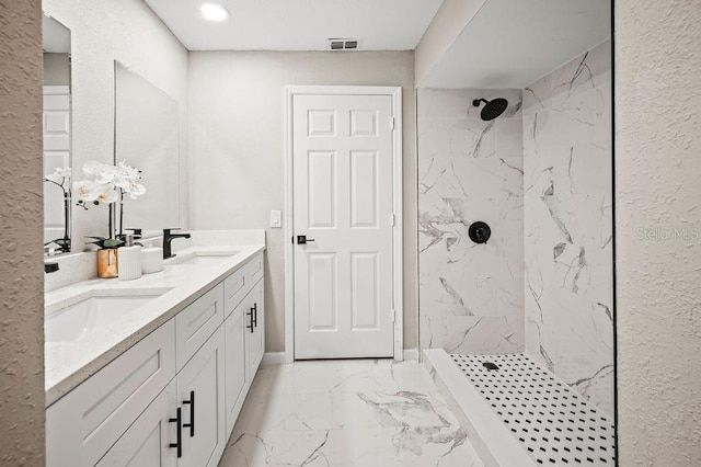 full bath featuring a sink, marble finish floor, visible vents, and a marble finish shower