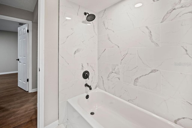 full bathroom featuring  shower combination, wood finished floors, and baseboards