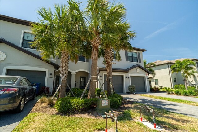 15242 Sunny Day Dr, Bradenton, FL 34211 - mediterranean / spanish-style house with stucco siding, concrete driveway, and an attached garage