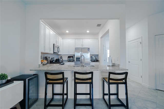 15242 Sunny Day Dr, Bradenton, FL 34211 - kitchen featuring stainless steel appliances, light stone countertops, a peninsula, and a sink