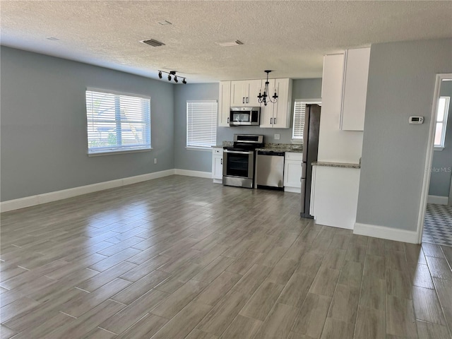 3735 Alabama Ave NE, Saint Petersburg, FL 33703 - kitchen featuring baseboards, visible vents, wood finished floors, and appliances with stainless steel finishes