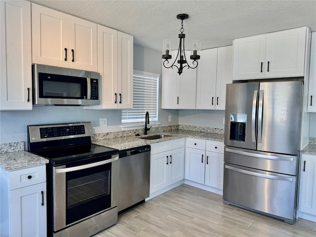 3735 Alabama Ave NE, Saint Petersburg, FL 33703 - kitchen featuring white cabinetry, a notable chandelier, appliances with stainless steel finishes, and a sink