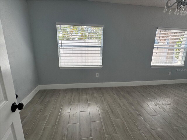 3735 Alabama Ave NE, Saint Petersburg, FL 33703 - spare room featuring a chandelier, baseboards, and wood finished floors