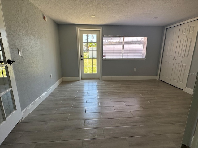 3735 Alabama Ave NE, Saint Petersburg, FL 33703 - interior space with wood finished floors, access to exterior, a textured wall, baseboards, and a textured ceiling