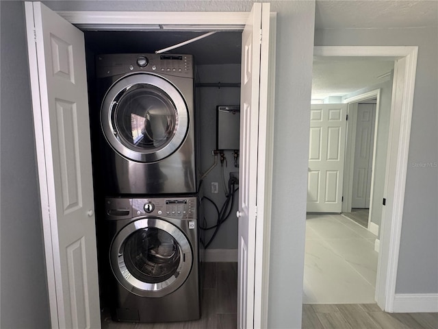 3735 Alabama Ave NE, Saint Petersburg, FL 33703 - washroom with stacked washer and clothes dryer, wood finished floors, laundry area, and baseboards