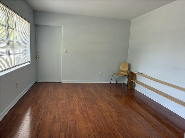 empty room featuring wood finished floors and baseboards