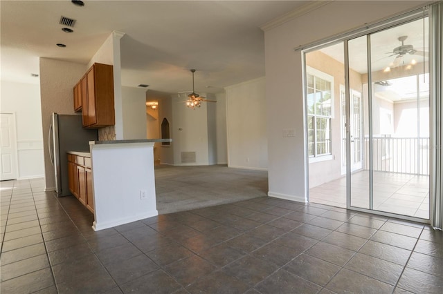 7613 Bay Port Rd Unit 34, Orlando, FL 32819 - kitchen featuring visible vents, arched walkways, ceiling fan, and brown cabinets