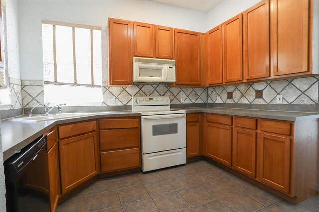 7613 Bay Port Rd Unit 34, Orlando, FL 32819 - kitchen with brown cabinetry, a sink, decorative backsplash, and white appliances