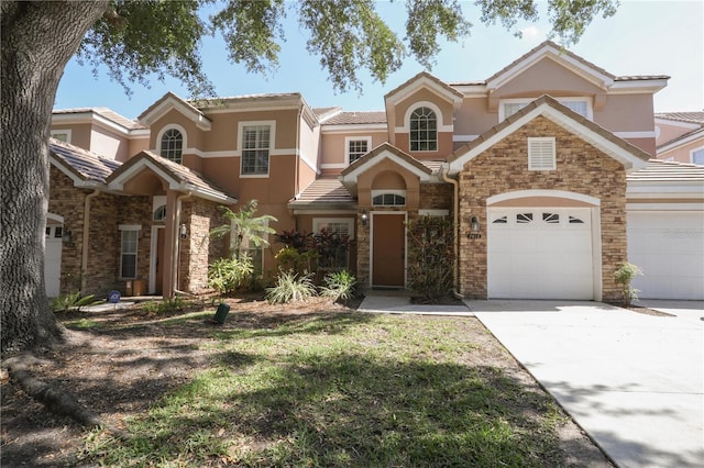 7613 Bay Port Rd Unit 34, Orlando, FL 32819 - view of front of house with stucco siding, a garage, driveway, and stone siding