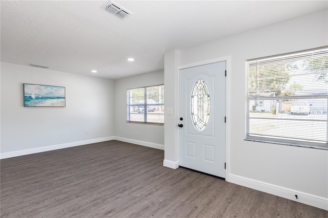 foyer entrance featuring wood finished floors, visible vents, and baseboards
