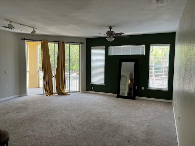 spare room featuring a ceiling fan, carpet floors, plenty of natural light, and baseboards