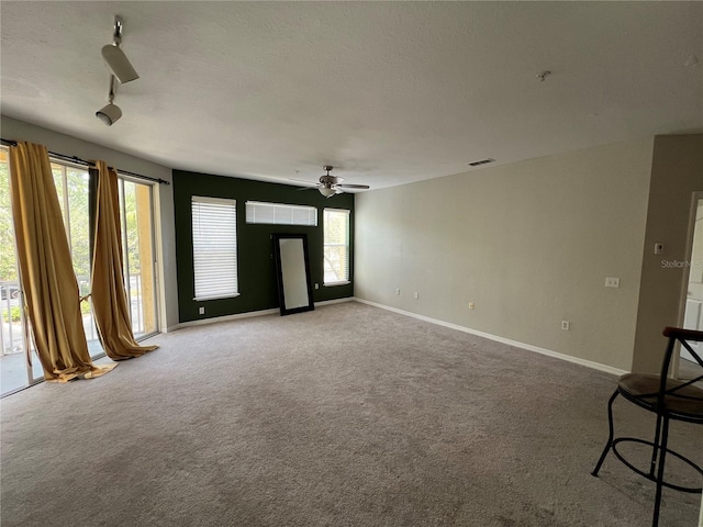 unfurnished living room featuring carpet flooring, ceiling fan, and healthy amount of natural light