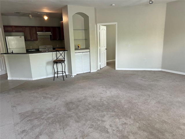 unfurnished living room featuring carpet and baseboards
