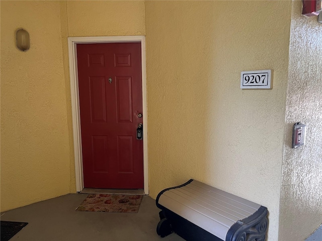 doorway to property featuring stucco siding