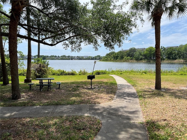 view of property's community with a water view and a lawn