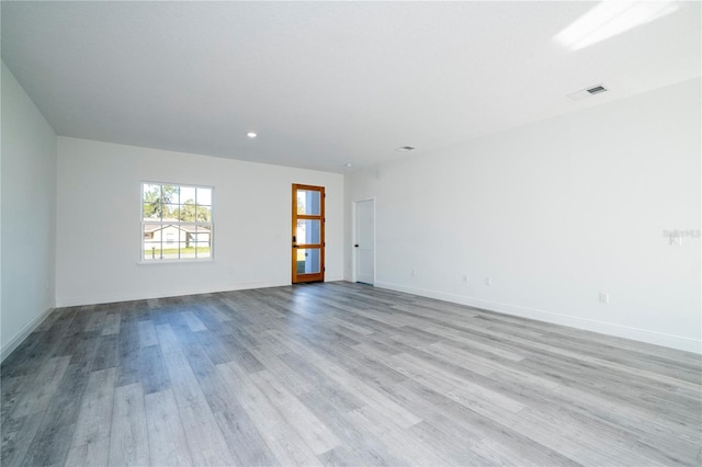 unfurnished room featuring baseboards, wood finished floors, visible vents, and recessed lighting