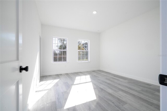 spare room featuring baseboards, wood finished floors, and recessed lighting