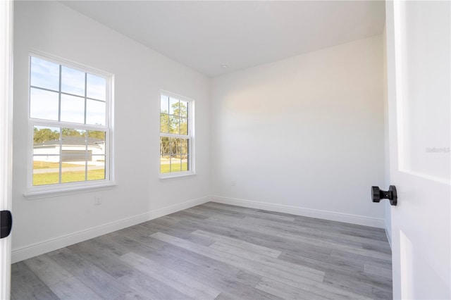 unfurnished room with baseboards and wood finished floors