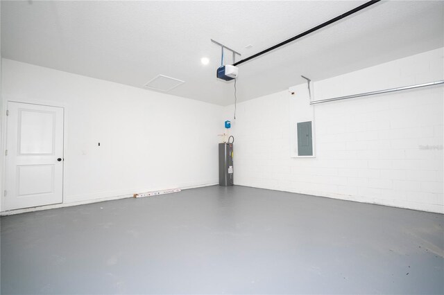 garage featuring concrete block wall, a garage door opener, electric water heater, and electric panel
