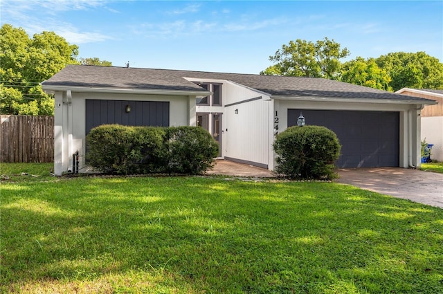ranch-style house featuring a garage, driveway, a front lawn, and fence