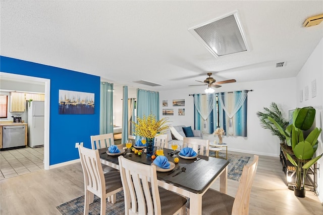 dining space with ceiling fan, baseboards, visible vents, and light wood finished floors