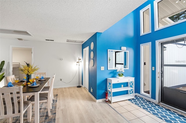 entryway featuring wood finished floors, a textured ceiling, baseboards, and visible vents