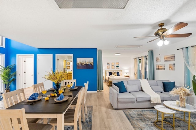living room with light wood finished floors, a textured ceiling, and ceiling fan