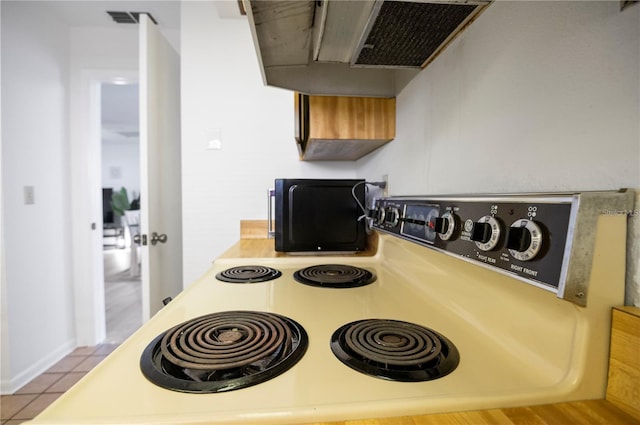 interior details with light countertops, range with electric cooktop, and visible vents