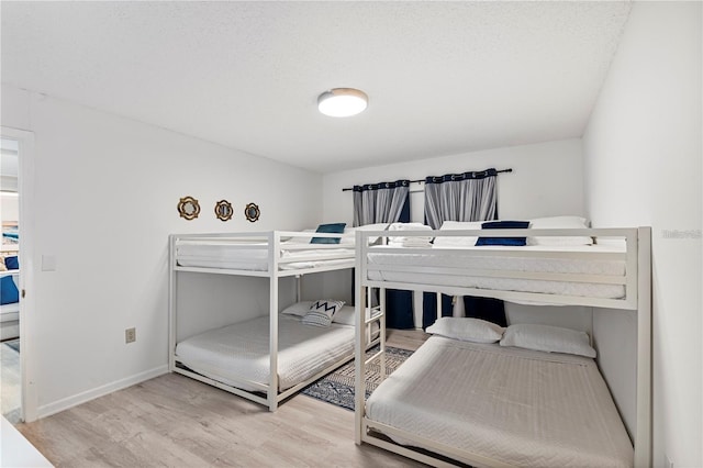 bedroom featuring wood finished floors and baseboards