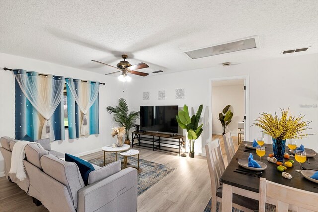 living room with visible vents, wood finished floors, and a textured ceiling