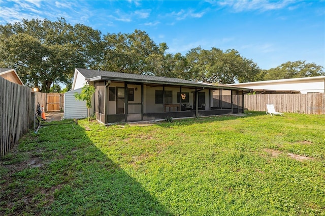 rear view of house featuring a lawn, a fenced backyard, and a sunroom