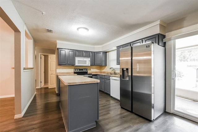 kitchen featuring a sink, gray cabinets, visible vents, light countertops, and appliances with stainless steel finishes