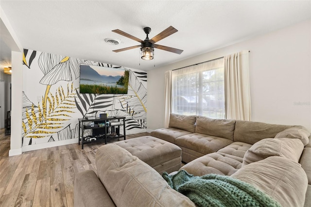 living area featuring wood finished floors, visible vents, and a ceiling fan