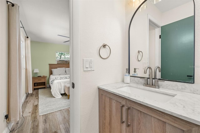 ensuite bathroom with vanity, wood finished floors, and ensuite bathroom