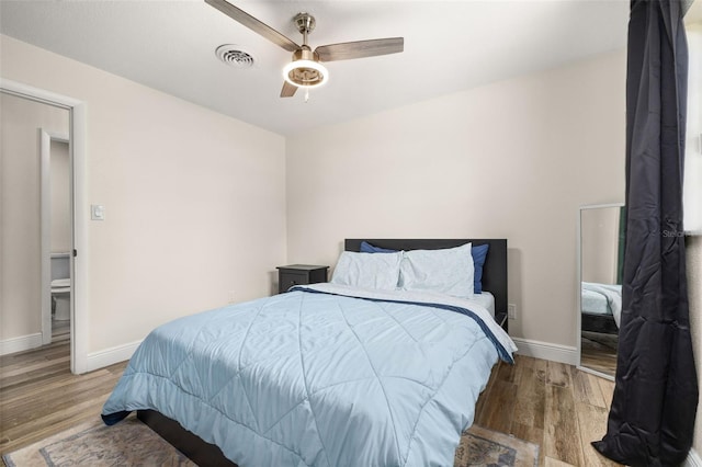 bedroom with visible vents, ceiling fan, wood finished floors, and baseboards