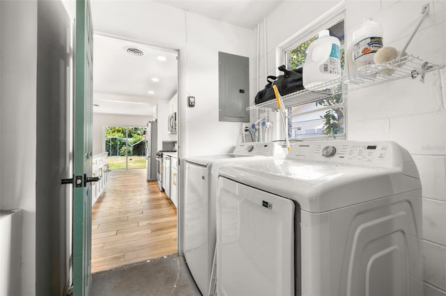 laundry area with light wood finished floors, electric panel, laundry area, visible vents, and washer and dryer