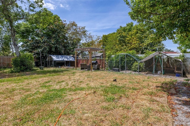view of yard with fence, exterior structure, and an outbuilding