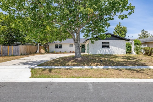 ranch-style house featuring fence and driveway