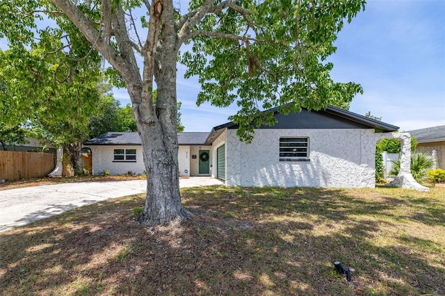 ranch-style house with stucco siding and fence